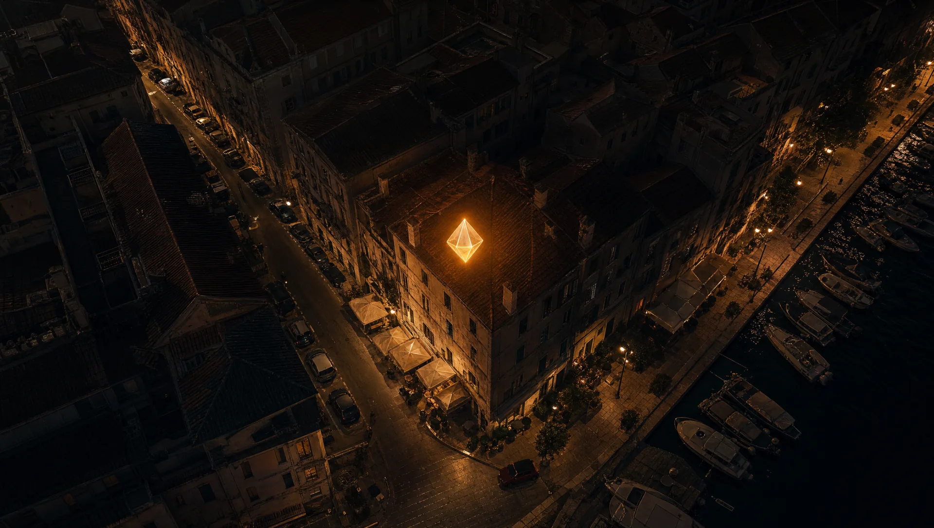 Toit d'un immeuble d'angle à Nice vu de près la nuit, un marqueur ambré au-dessus